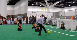 AI100 standing committee chair Peter Stone takes a shot against a robot goalie at RoboCup 2019 in Sydney