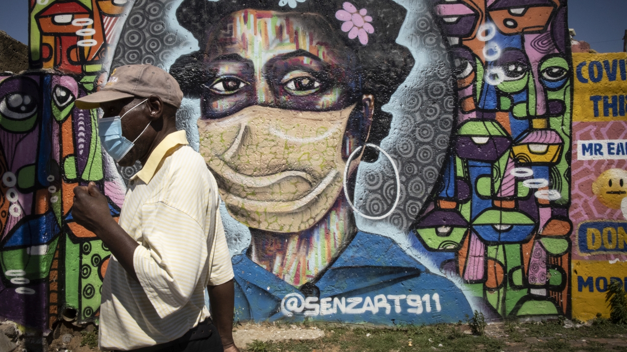 A Soweto resident walks in front of an informative graffiti art work educating local Soweto residents about the dangers of the coronavirus, Johannesburg, South Africa, 30 November 2021. South Africa's government is considering mandatory vaccinations for all citizens as it tries to educate and vaccinated its population after the new Omicron variant of SARS-CoV-2, the virus that causes COVID-19, was detected. Several countries banned travel with Southern African countries including South Africa due to the Omicron variant